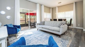 Una sala de estar con sofá, una mesa de centro y una zona de comedor con sillas.