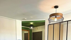 Una sala de estar moderna con un sofá, dos mesas redondas, un televisor de pantalla plana y una lámpara decorativa.