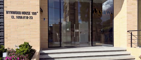 The entrance to Wynwood House 109 with a glass door, brick facade, and steps leading up to the entrance.