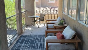 A covered outdoor seating area with a ceiling fan, a small table, and a chair. - TPC golf course North Scottsdale. (Scottsdale)
