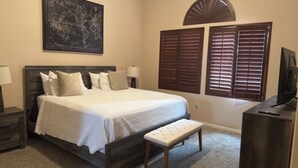 A bedroom with a large bed, a bench, a desk, and a map on the wall. - TPC golf course North Scottsdale. (Scottsdale)