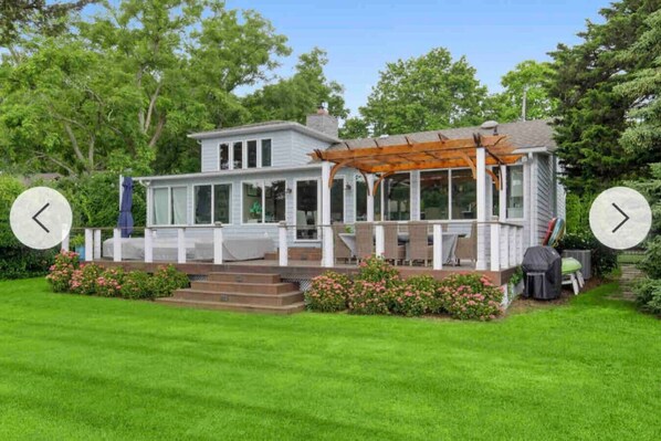 A house with a covered porch, a lawn, and a garden.