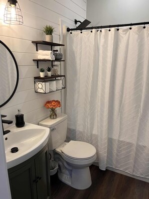 Een moderne badkamer met toilet, wastafel en planken met toiletartikelen.