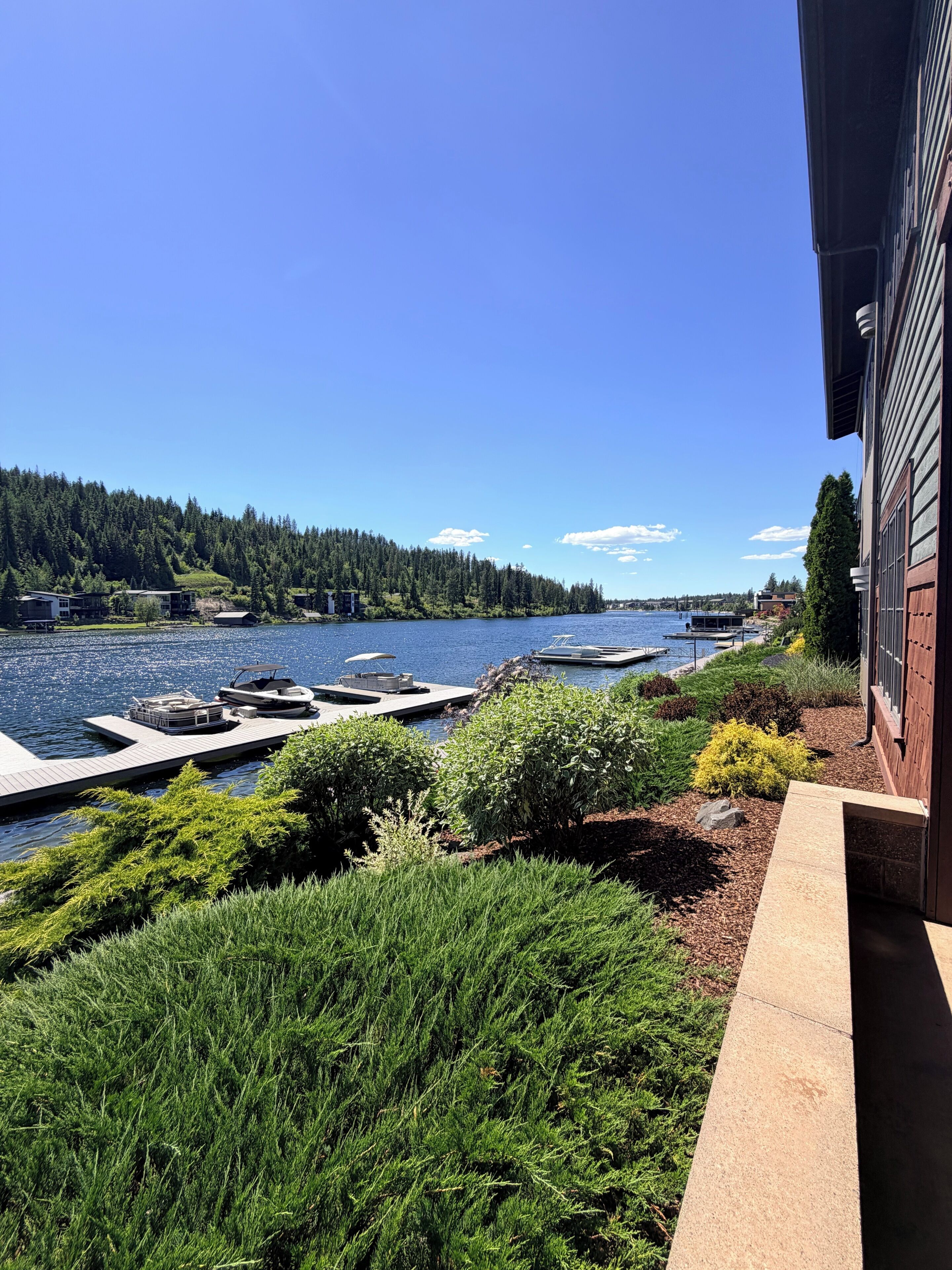 A lakeside property with a dock, boats, and a view of the water.