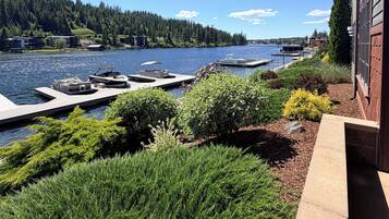 A lakeside property with a dock, boats, and a view of the water.