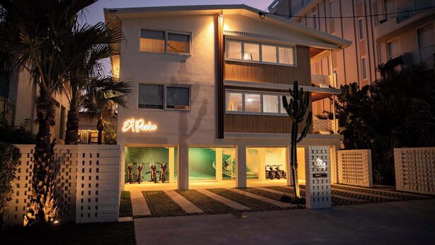 Un hôtel moderne, doté d’une enseigne lumineuse au néon, de plusieurs étages et d’une entrée bien éclairée.