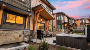 A modern multi-story house with stone and wood exterior, outdoor seating, and a hot tub. - Hot Tub, BBQ & Mtn Views Near Deer Valley & Park City Deer Valley East Retreat by Avantstay (Heber City)