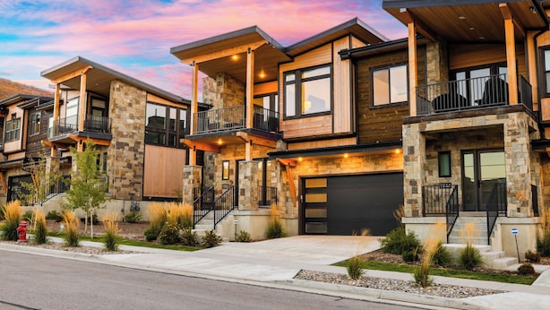 A modern multi-story residential building with stone and wood exterior, balconies, and a garage. - Hot Tub, BBQ & Mtn Views Near Deer Valley & Park City Deer Valley East Retreat by Avantstay (Heber City)