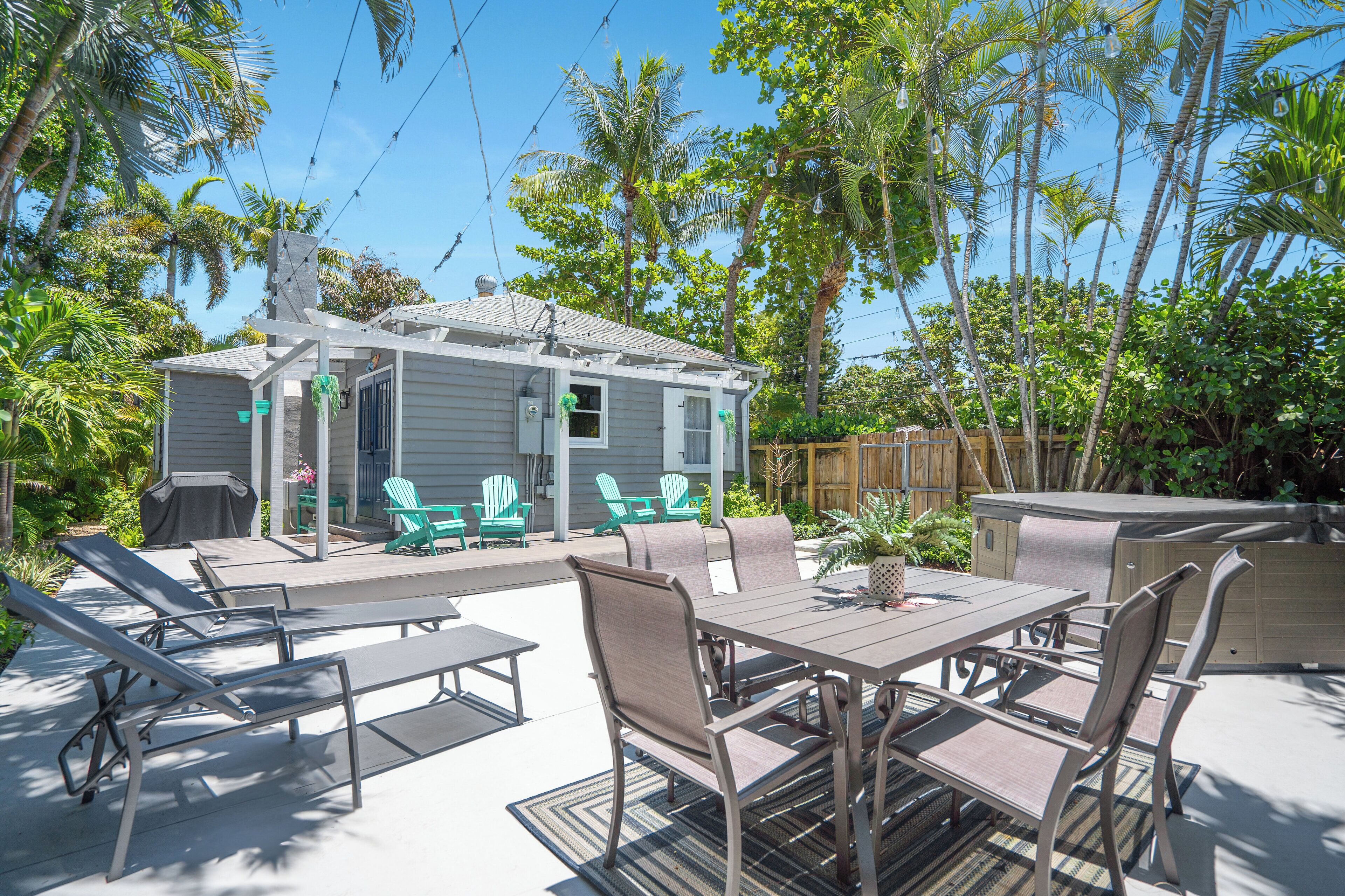 A patio with a table and chairs, a grill, and a pool.