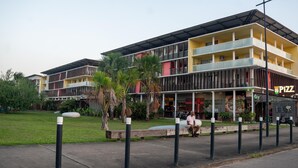 A multi-story building with a restaurant named "PIZZA" on the ground floor. - Cocon Chic  Res de Charme (Cayenne)