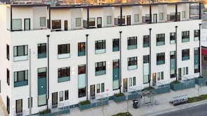 A multi-story building with a white facade, large windows, and a flat roof.