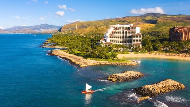 A coastal hotel with multiple buildings, a beach, and rocky outcrops. - Modern Family Beach Villa near shops and dining (Kapolei)