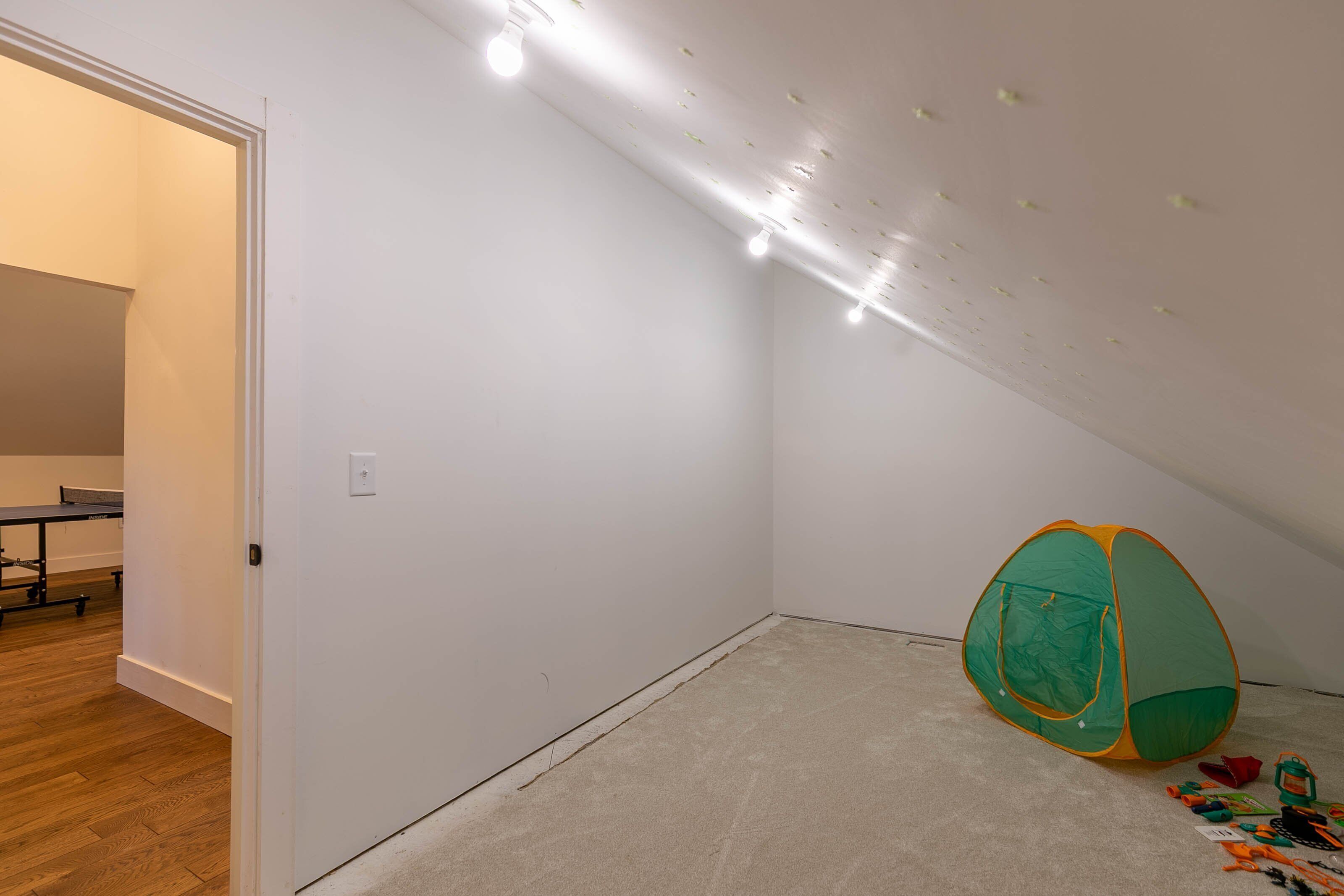 A room with a tent, a ping pong table, and a carpeted floor.