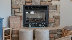 A fireplace with a stone facade, a 'welcome' sign, and a 'RELAX' sign in front. - Summerset Poolside Paradise (Manson)
