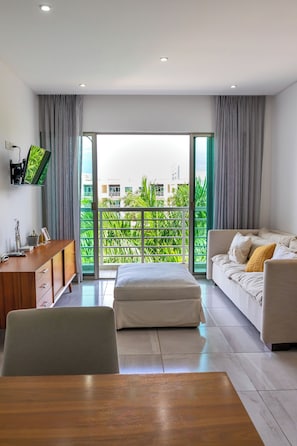 Familie appartement, uitzicht op zwembad | Woonruimte | Een 43-inch flatscreentelevisie met kabelzenders