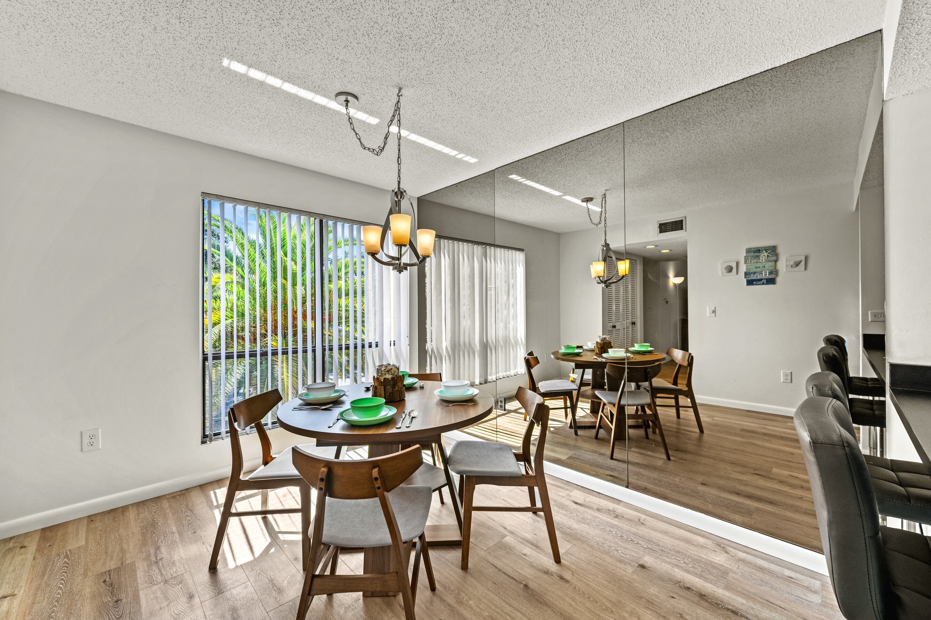 Un espace de salle à manger moderne avec une table ronde, des chaises en bois et des luminaires suspendus.