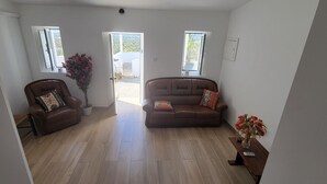 Una sala de estar con dos sofás de cuero marrón, una mesa de centro de madera y una planta en maceta.