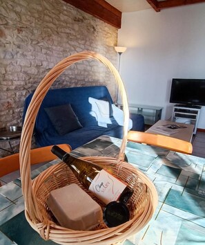 Una cesta de mimbre con una botella y una caja sobre un suelo de baldosas.