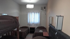 A dormitory room with bunk beds, a desk, a chair, a mirror, and a window with curtains. - Petit Hotel (Mendoza)