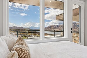 Un dormitorio con un amplio ventanal que ofrece vistas a la montaña.