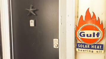 A door with a star-shaped decoration, a keypad lock, and a sign for Gulf Solar Heat heating oil.