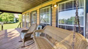 A covered porch with wicker furniture and large windows. - 1 Mi to Downtown Eureka Springs: Studio Retreat (Eureka Springs)