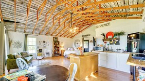 A spacious living area with a wooden ceiling, a dining table with chairs, a kitchen area with white cabinets, and a sign indicating no vacancy. - 1 Mi to Downtown Eureka Springs: Studio Retreat (Eureka Springs)