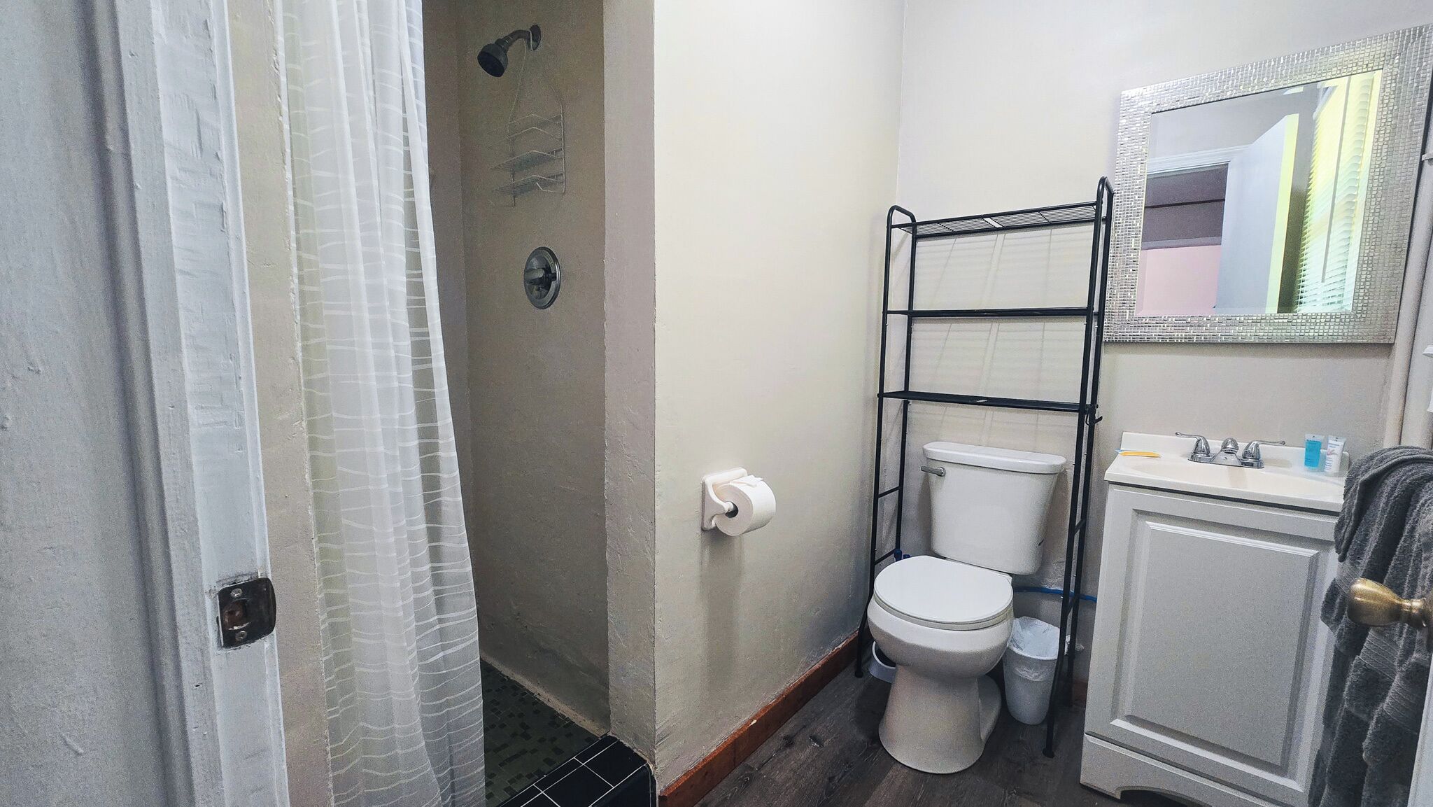 Een badkamer met toilet, douche en wastafel.