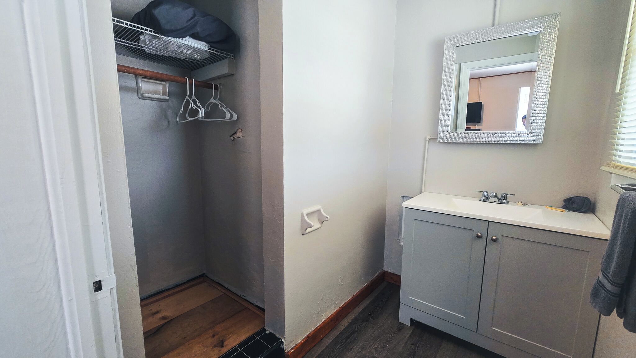 A bathroom with a white sink, a mirror, and a shower area.