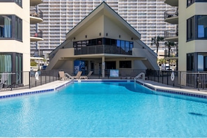 A swimming pool with a modern building in the background.