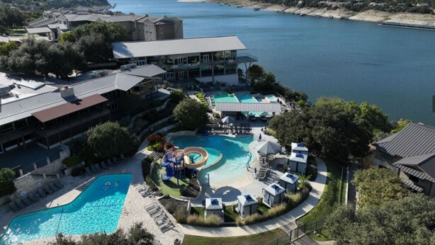Un resort con una piscina grande, un tobogán de agua y vistas al lago.