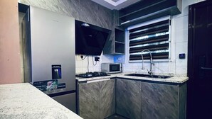A modern kitchen with a built-in microwave, stove, and sink. - Luxury 3-Bedroom Home in Maitama Abuja (Abuja)