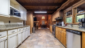 A kitchen with wooden cabinets, a dishwasher, a microwave, and a stove.