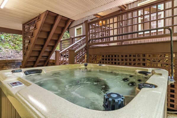 Un jacuzzi con cubierta de madera y escaleras que conducen a un segundo nivel.