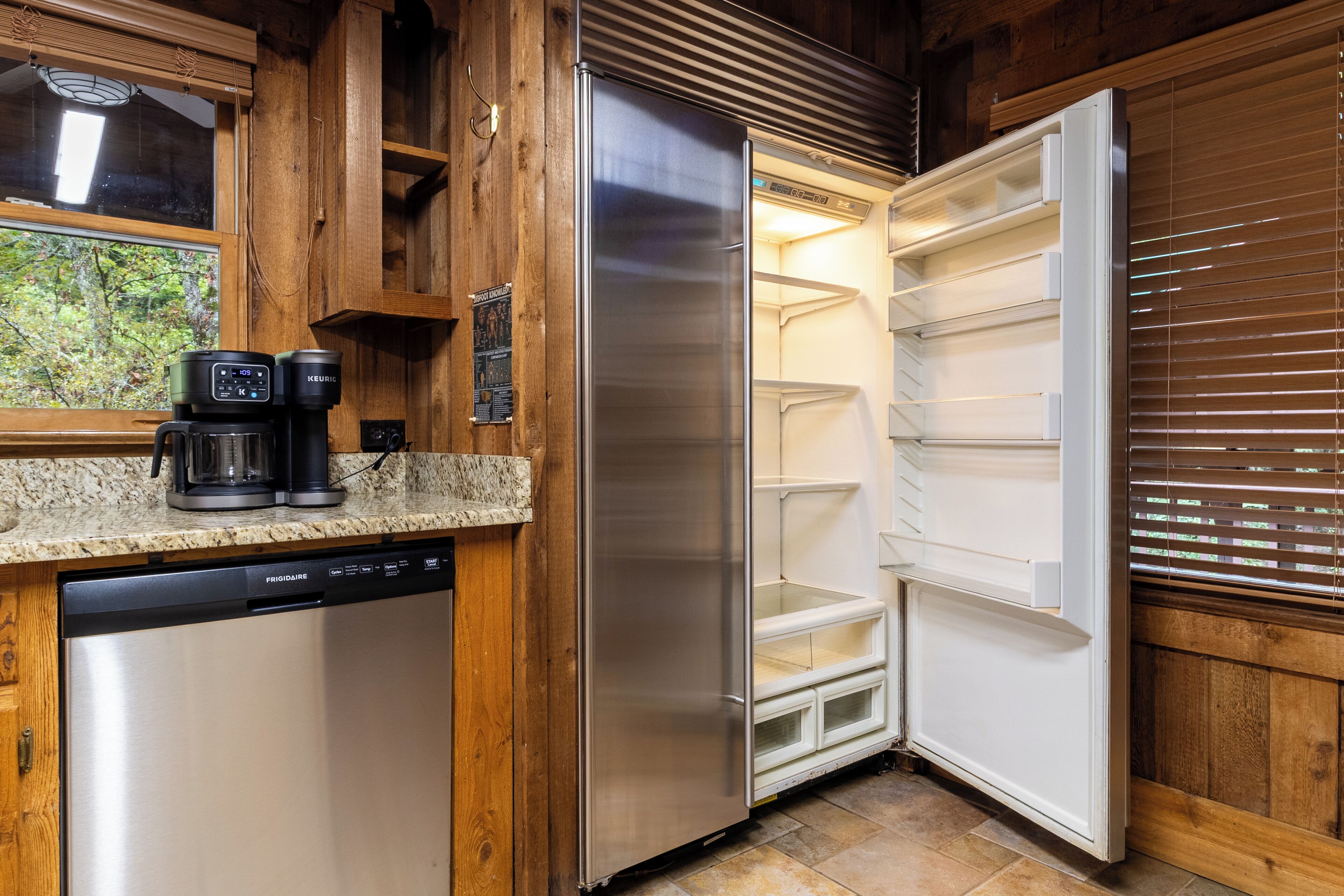 A modern kitchen with a stainless steel refrigerator, a coffee maker, and a dishwasher.