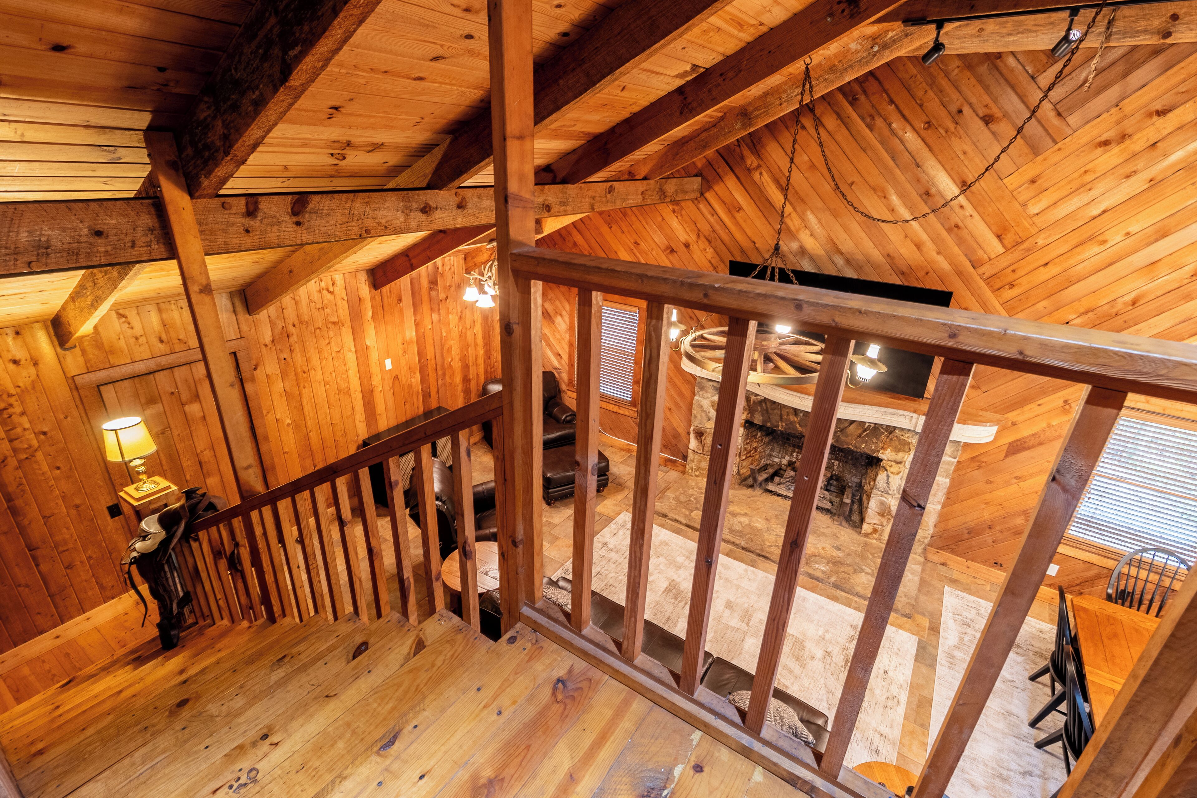A wooden interior with a wooden staircase, a fireplace, and a dining area.