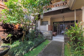 A traditional house with a garden entrance, a wooden fence, and a staircase leading to the main building. - Griya Agung Guesthouse Ubud (Ubud)
