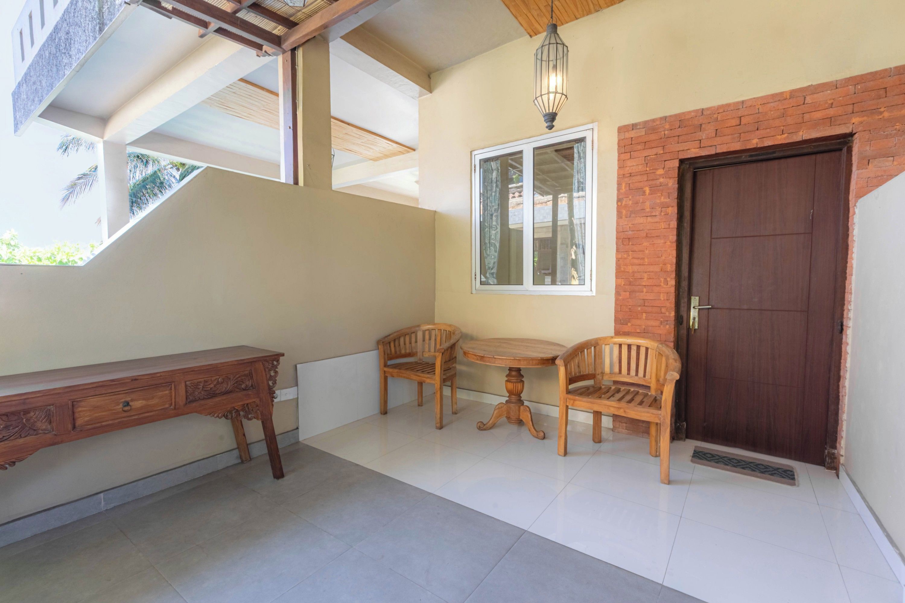 Une pièce comprenant un bureau, deux chaises, une petite table, une fenêtre et une porte.
