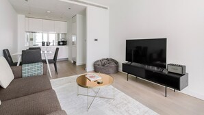 Un salon moderne avec un canapé, une table basse et un téléviseur à écran plat.