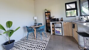 Una cucina compatta con zona pranzo, una pianta in vaso e una libreria.