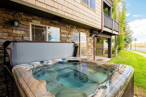 Ein Whirlpool vor einem Steinhaus mit einem Balkon.