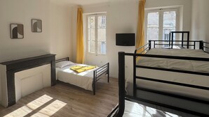 A room with a bunk bed, a desk, a chair, and a bed with a yellow blanket. - Nuitéa Résidence  (Marseille)