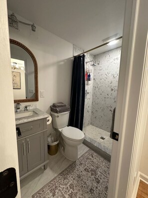 A bathroom with a toilet, sink, and shower.