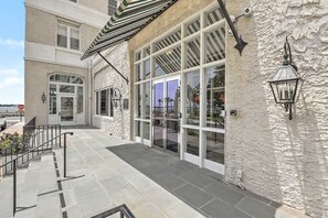 A building with a stone facade, large windows, and a metal staircase.