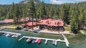 A lakeside lodge with multiple buildings, a dock with boats, and a forested backdrop. - Townhouse w/Lake View #254 at Donner Lake Village (Truckee)