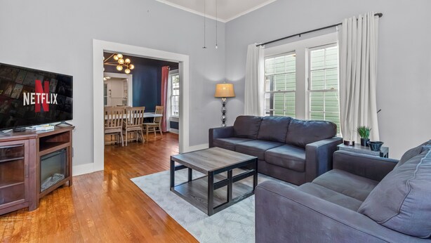 A living room with a flat-screen TV, a wooden coffee table, and a gray sofa. - Charming 3BR Downtown Natchitoches Home, 1.5 Bath, Walking Distance to Front St (Natchitoches)