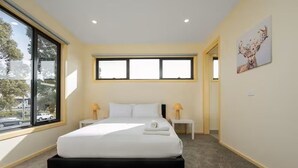 Una camera da letto moderna con un letto grande, due comodini, una finestra e un quadro appeso al muro.