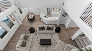Un vaste espace de vie comprenant un ensemble de canapés, une table basse et une table à manger avec des chaises.