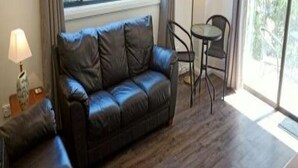 Ein Wohnzimmer mit einem dunkelbraunen Ledersofa, einem kleinen Tisch und einem Sessel.