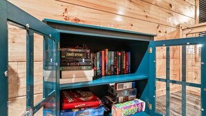 Una libreria in legno con libri e giochi da tavolo.